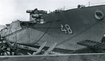 这是西弗吉尼亚号(BB-48)在拆解中的照片。可以看到虽然上层建筑和最上层甲板的一部分已经被拆除，舰艏的Mk5 16英寸主炮的炮座，以及B炮塔的一部分装甲仍然留在船上。
